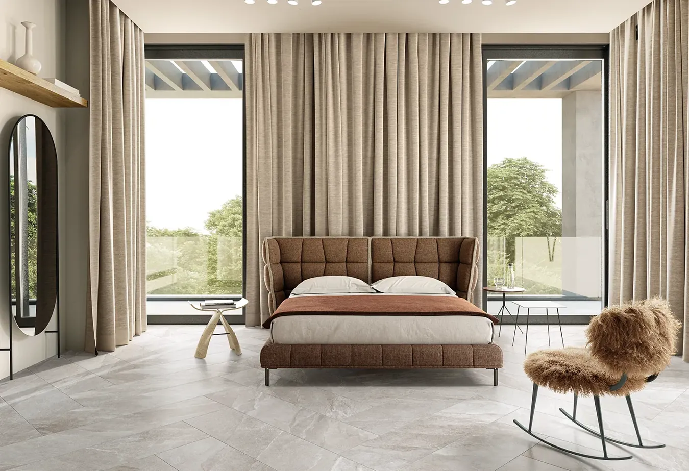 Camera da letto elegante con piastrelle effetto pietra greige della collezione Ubik, letto imbottito marrone e tende coordinate.